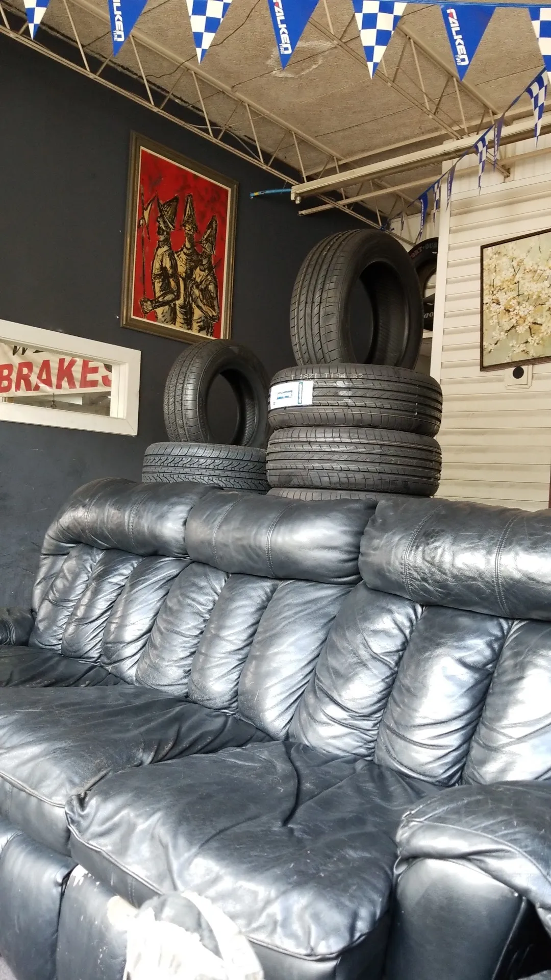 Inside Tire City, tires stacked near a hand-painted brakes sign