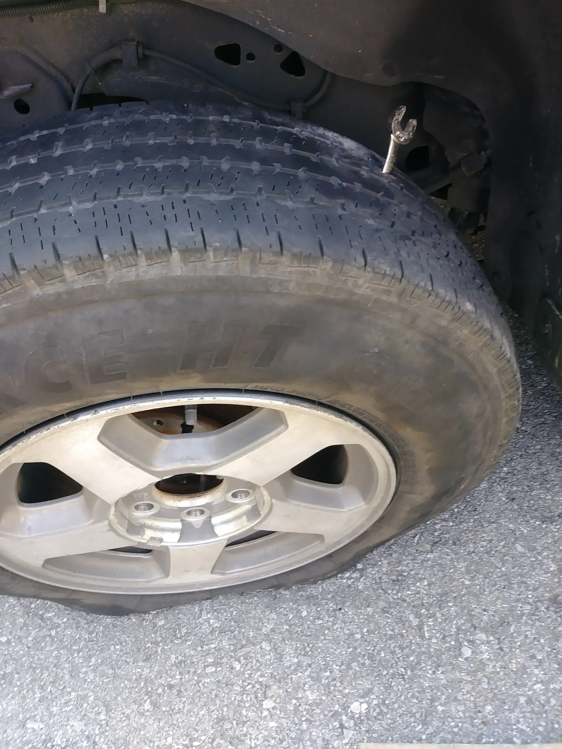 Close-up of a tire tread and wheel being inspected